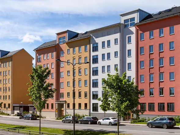 Färgstarka flerbostadshus längs en gata i projektet Skogsstjärnan i Hässelby.