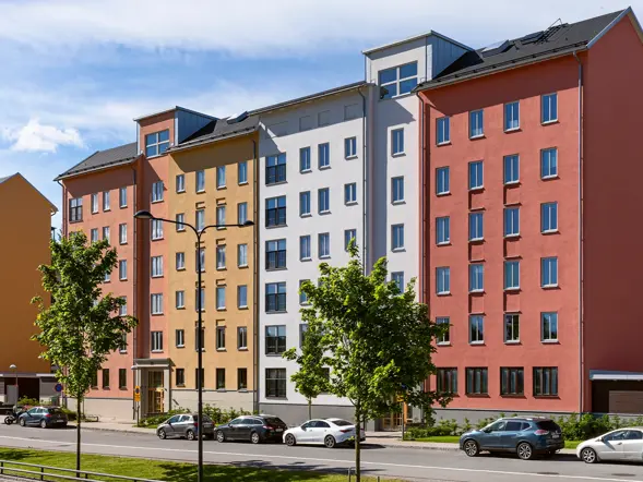 Färgstarka flerbostadshus längs en gata i projektet Skogsstjärnan i Hässelby.