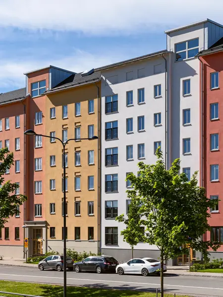 Färgstarka flerbostadshus längs en gata i projektet Skogsstjärnan i Hässelby.