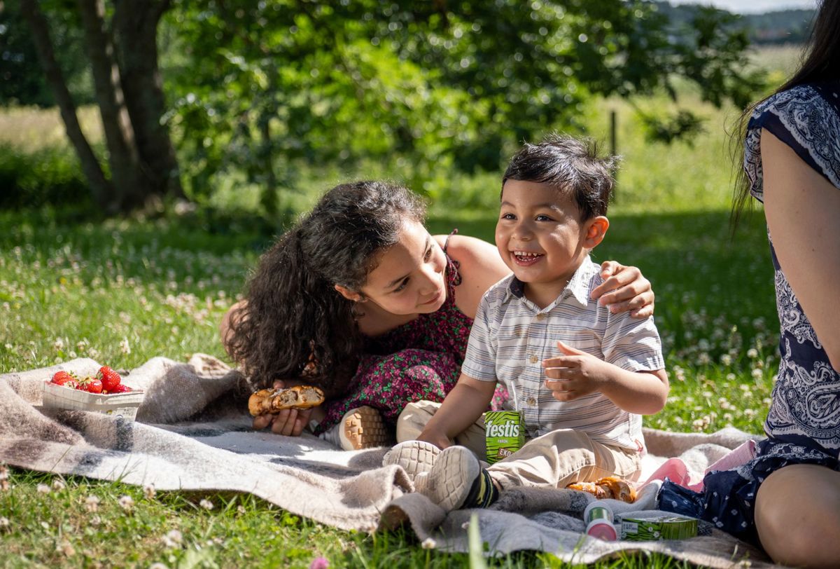 En familj har picknick i en grön parkmiljö nära Sjöängen i Upplands Väsby.
