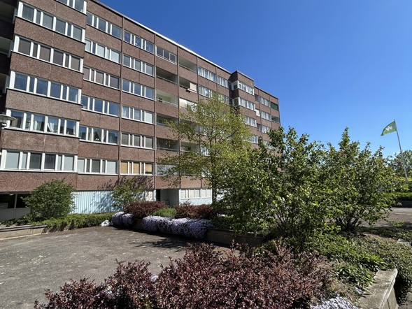 Fasad på ett flerbostadshus med hyreslägenheter och grönska i Västerås.