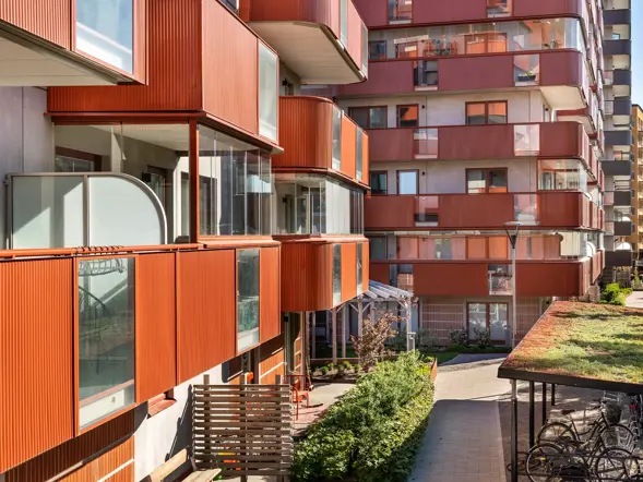 Färgstarka balkonger och en grön bostadsgård vid Årstahusen.