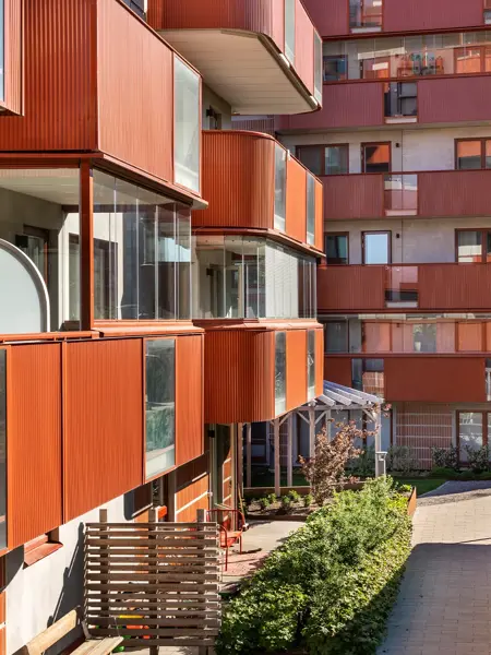 Färgstarka balkonger och en grön bostadsgård vid Årstahusen.