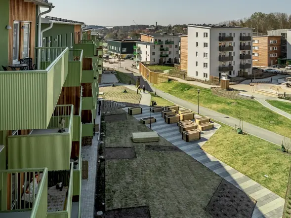 Grönt flerbostadshus med balkonger och gård i Järvastaden.