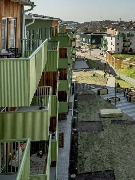 Grönt flerbostadshus med balkonger och gård i Järvastaden.