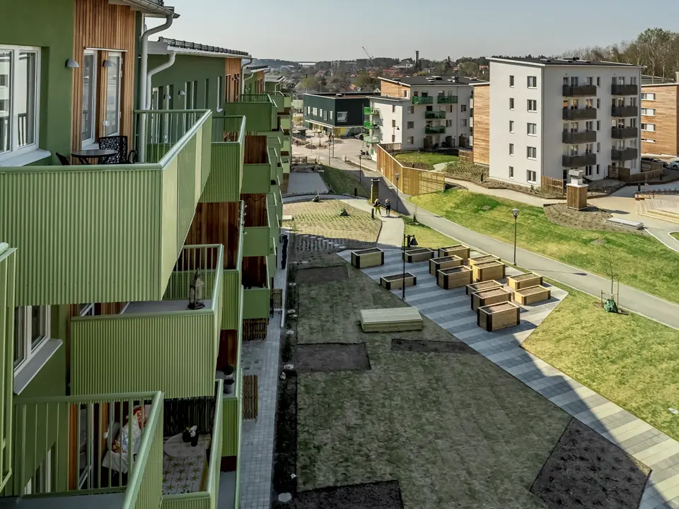 Grönt flerbostadshus med balkonger och gård i Järvastaden.