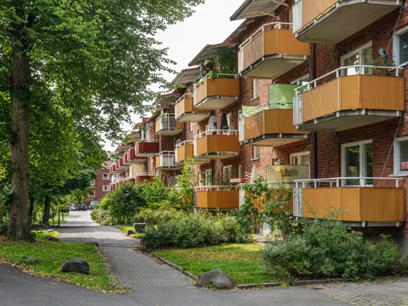 fastigheter-stockholm-hagsatra-tegelbyggnad-balkonger-gangvag.webp
