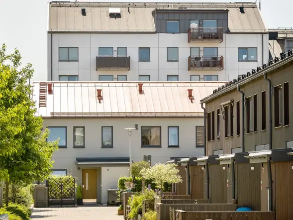 Radhus och flerbostadshus med innergård och grönska mellan husen.