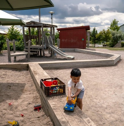 Barn leker med en leksaksbil vid sandlådan på lekplatsen vid Eds Allé.