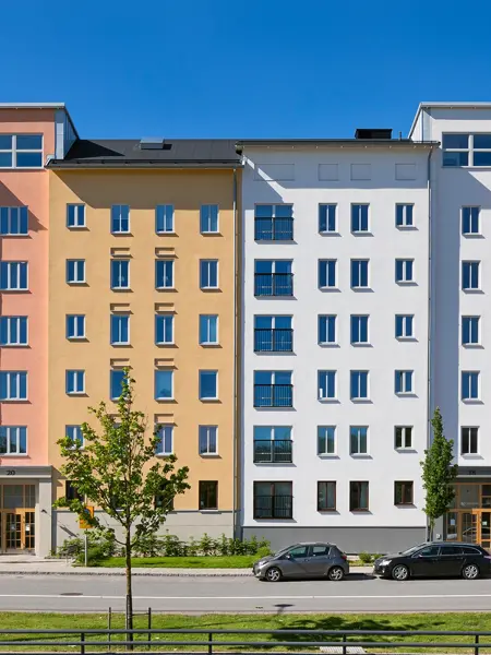Flerbostadshus med gula, blå och röda fasader i projektet Skogsstjärnan i Hässelby.